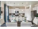 Bright dining area with white cabinets, modern appliances, pendant lighting, and stylish decor at 226 Chardon Ave, Brighton, CO 80601