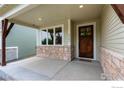 Inviting front porch with stone accents, dark wood door, and bright windows at 2397 Bristol St, Superior, CO 80027