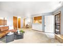 Open-concept living area with an eat-in kitchen, balcony access, and comfortable seating at 2800 Kalmia Ave # C205, Boulder, CO 80301