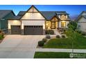Charming two-story home with a well-manicured lawn, stone accents, and an attached two-car garage at 2932 Heron Lakes Pkwy, Berthoud, CO 80513