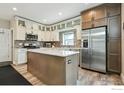 Bright kitchen with white cabinets, stainless steel appliances, granite countertops, and central island at 3165 W 63Rd Ave, Denver, CO 80221