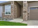 Inviting entrance with stone pillars, a covered porch, and a clear view of the house number at 3166 Newfound Lake Rd, Berthoud, CO 80513