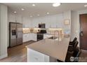 Bright kitchen featuring quartz countertops, a stainless steel refrigerator, and barstool seating at 3301 Arapahoe Ave # 415, Boulder, CO 80303