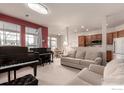 Cozy living room featuring pianos, a comfortable sofa, and access to the kitchen and dining area at 3577 Molly Cir, Broomfield, CO 80023