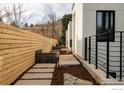 Landscaped side yard featuring concrete pavers, planter boxes, privacy fence, and modern black railings at 358 Arapahoe Ave # B, Boulder, CO 80302