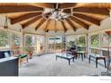 Bright living room featuring a wood ceiling, a ceiling fan, large windows, and a sliding door to the deck at 394 Deer Trail Cir, Boulder, CO 80302