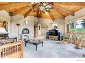 Spacious living room with a unique wood ceiling, fireplace, comfortable seating, and views of the surrounding landscape at 394 Deer Trail Cir, Boulder, CO 80302