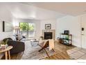Inviting living room featuring a fireplace, balcony access, neutral walls, and wood-look flooring at 4670 White Rock Cir # 1, Boulder, CO 80301