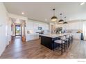 Open-concept kitchen with an island, pendant lighting, stainless steel appliances, and bar stool seating at 4918 Preserve Pl, Firestone, CO 80504