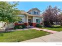 Charming home with a well-manicured lawn, red brick accents and colorful trees at 4926 Pasadena Way, Broomfield, CO 80023