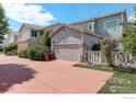 Attached two-car garage with a large driveway and mature landscaping at 4926 Pasadena Way, Broomfield, CO 80023