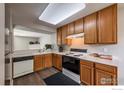 Bright kitchen with laminate wood flooring, white appliances, and ample storage at 51 21St Ave # 43, Longmont, CO 80501