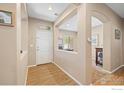 Inviting foyer with light-colored walls and wood-look flooring leads to the rest of the home at 64 Whitehaven Cir, Highlands Ranch, CO 80129
