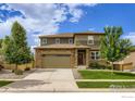 Charming two-story home with a stone and siding exterior, featuring a two-car garage and landscaped front yard at 71 Sugar Beet Cir, Longmont, CO 80501