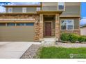 Inviting home facade showcasing a stone accent wall and front door with green wreath detail at 71 Sugar Beet Cir, Longmont, CO 80501