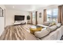 Bright living room with wood floors, a modern accent wall, and a comfortable sectional sofa at 71 Sugar Beet Cir, Longmont, CO 80501