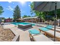 Inviting pool area featuring lounge chairs, umbrellas, and a cabana for a relaxing outdoor experience at 7451 Rozena Dr, Longmont, CO 80503