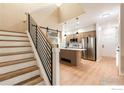 Modern kitchen featuring stainless steel appliances, island, and open staircase access at 829 Kane Dr # 23, Longmont, CO 80501