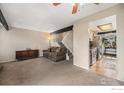 Cozy living room featuring comfortable seating, staircase, and view to kitchen at 8746 Carr Loop, Arvada, CO 80005