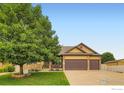 Charming home with a three-car garage, a covered porch, and mature trees at 9629 Bountiful St, Firestone, CO 80504