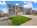 Beautiful two-story home featuring a two-car garage, covered porch, and manicured lawn at 1038 Scotts Peak Dr, Berthoud, CO 80513