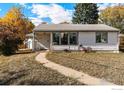 Inviting single-story home featuring a well-maintained lawn and a charming walkway to the front door at 1109 Ironton St, Aurora, CO 80010