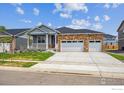 Inviting single-story home featuring a stone facade and a three-car garage at 1144 Ridgefield Dr, Berthoud, CO 80513