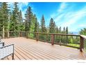 Spacious deck with modern railings offering picturesque views of the surrounding forest at 1176 Raven Ridge Rd, Idaho Springs, CO 80452
