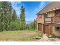 Side of the house with two garage doors and an American flag on the balcony at 1176 Raven Ridge Rd, Idaho Springs, CO 80452