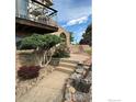 Charming entrance with a brick archway, landscaped pathway, and a cozy balcony above at 13748 Downing St, Brighton, CO 80602