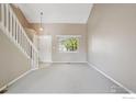 Bright living room with neutral carpet, a large window, and staircase at 1506 Crestwood Cir, Longmont, CO 80504