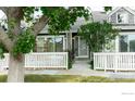 Charming home with a front patio, white picket fence, and mature trees at 154 Blue Spruce Ct, Highlands Ranch, CO 80126