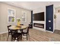 Modern dining area features wood floors, fireplace, and ample natural light at 173 Ambrose St, Erie, CO 80516