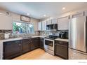 Modern kitchen with stainless steel appliances, sleek countertops, and ample cabinet space for storage at 1747 Daisy Ct, Brighton, CO 80601