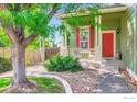 Inviting porch with a red front door, decorative columns, and stone landscaping, creating a welcoming entrance at 1747 Daisy Ct, Brighton, CO 80601