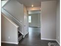 Entry hallway with wood floors, white trim, and view into an open floor plan at 1759 Jennifer St, Brighton, CO 80601
