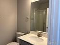 Well-lit bathroom featuring a single sink vanity, toilet, and enclosed shower at 1783 Jennifer St, Brighton, CO 80601