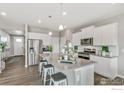 Modern kitchen with white cabinets, stainless steel appliances, and a spacious island with seating for three at 1907 Mount Monroe Dr, Berthoud, CO 80513