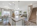 Bright, open concept kitchen with a large island, seamlessly connecting to the dining and living areas at 1907 Mount Monroe Dr, Berthoud, CO 80513