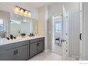 Bright bathroom with double vanity, quartz countertop, and doorway to bedroom at 2715 Crystal Springs Ln, Longmont, CO 80503
