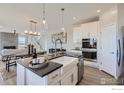Open-concept kitchen featuring white cabinetry, a large island, and dining area at 2715 Crystal Springs Ln, Longmont, CO 80503