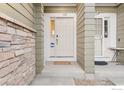Close-up of a front door and stone facade providing a welcoming entry to the home at 3000 E 112Th Ave # 102, Northglenn, CO 80233