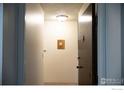 Entryway with a brown door, intercom system, and a glimpse into the interior space at 3150 Iris Ave # 303, Boulder, CO 80301