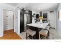 Modern kitchen with stainless steel appliances, island with seating and dark cabinetry at 3730 Lowell Blvd, Denver, CO 80211