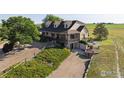 Exterior elevation highlighting a country-style home with a brick facade and lush landscaping at 420 E County Road 10, Berthoud, CO 80513