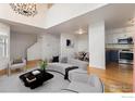 Open living room with hardwood floors, modern decor, a staircase and an adjacent eating nook and kitchen at 5174 Buckingham Rd, Boulder, CO 80301