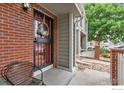 Inviting front porch with brick columns and a cozy seating area at 7474 E Arkansas Ave # 12, Denver, CO 80231