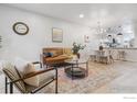 Open concept living area with hardwood floors, modern furniture, and abundant natural light at 7474 E Arkansas Ave # 12, Denver, CO 80231