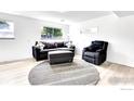 Cozy living room features a dark sofa and chair, a neutral rug, and natural light at 8030 Ogden St, Denver, CO 80229