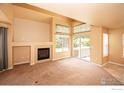 Living room featuring a fireplace, carpeted floor, sliding glass door, and large windows providing natural light at 805 Summer Hawk Dr # B7, Longmont, CO 80504